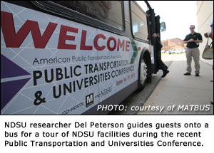 Picture of NDSU researcher Del Peterson guides guests onto a bus for a tour of NDSU facilities during the recent Public Transportation and Universities Conference.